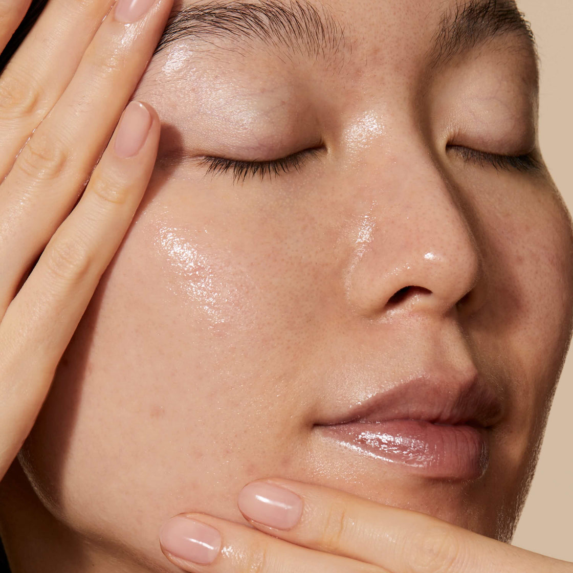 A model applying the Queen Essence to her face. Her skin looks hydrated and refreshed 